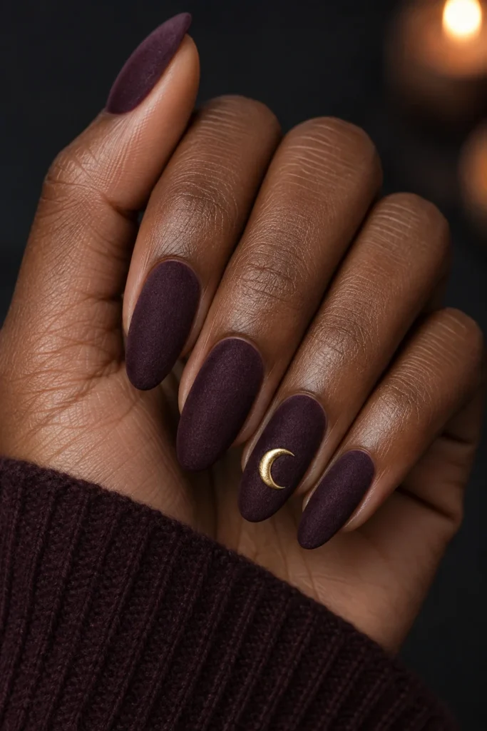 Matte deep plum velvet nails with a tiny gold crescent moon
