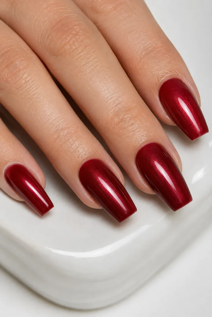 Glazed dark red coffin nails with a pearly glossy finish