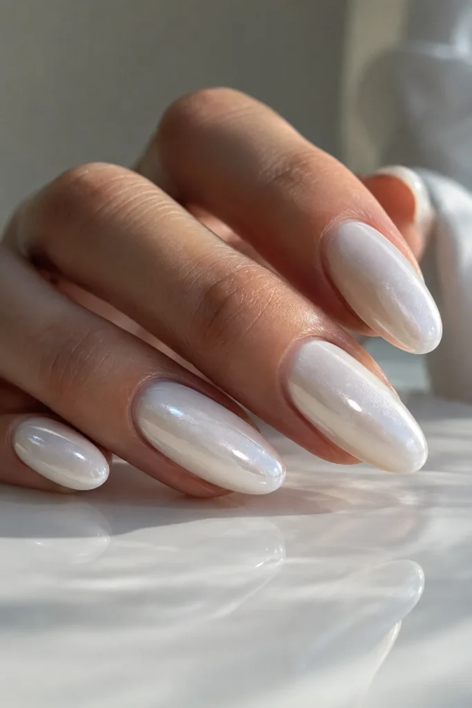 Glazed white nails with pearly shimmer on almond nails