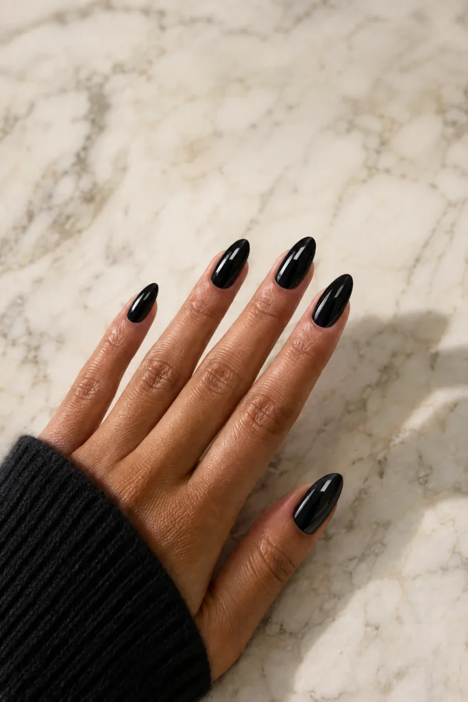 Glossy jet black almond nails with a sleek high-shine finish for summer
