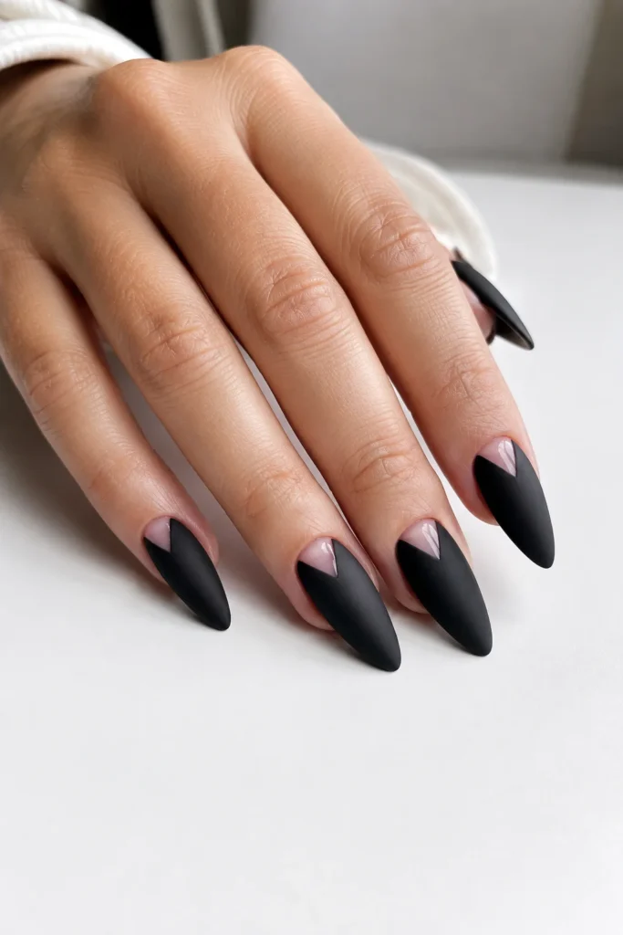 Matte black stiletto nails featuring negative space