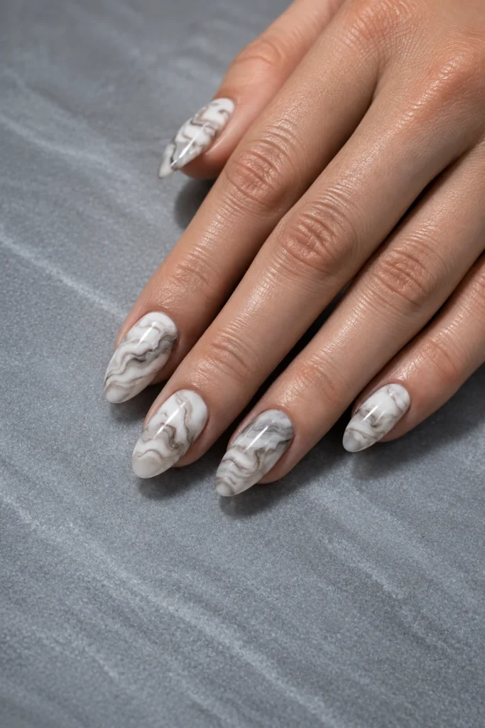 Milky white marble swirl nails featuring soft beige and gray accents