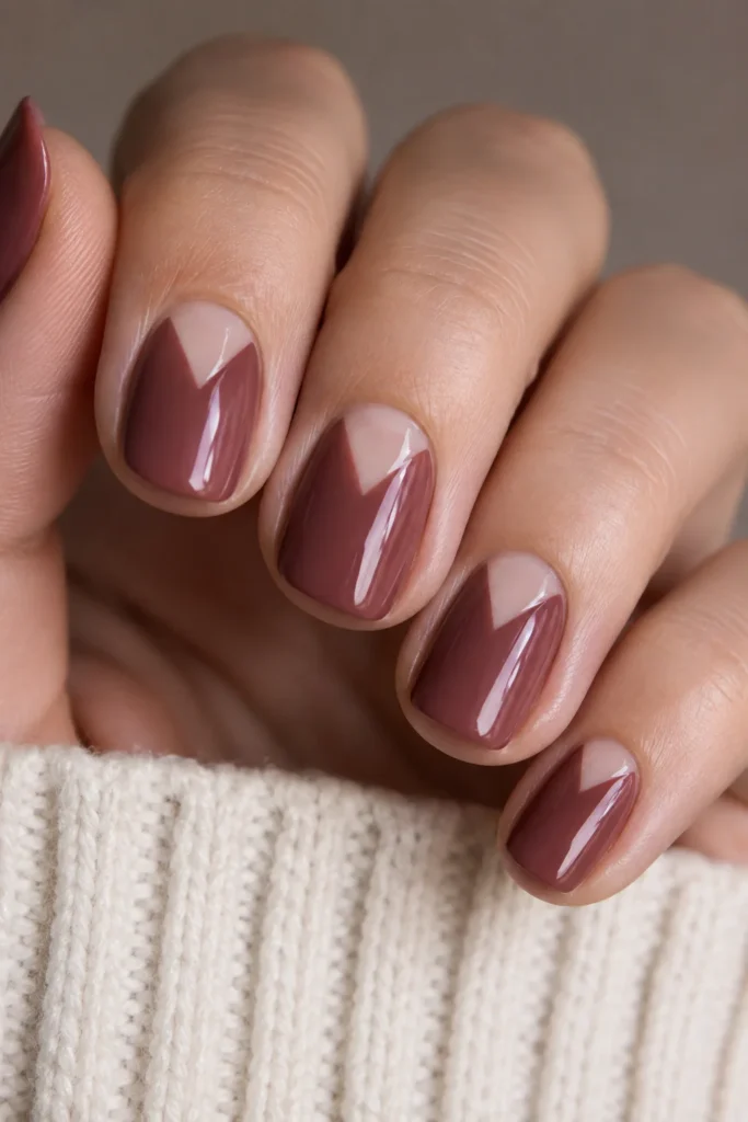 Mauve short almond nails with a negative space triangle design