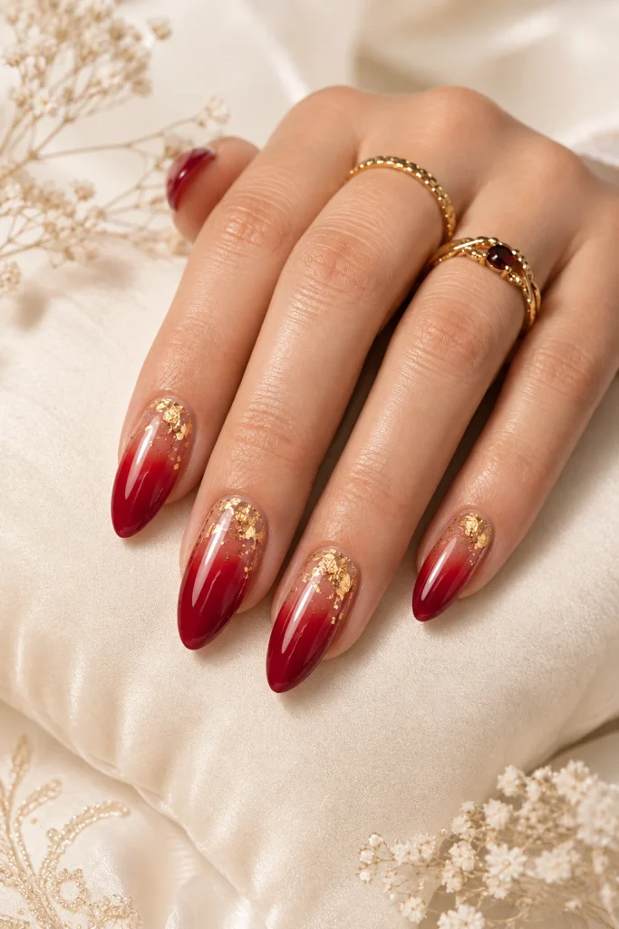Red ombre nails with delicate gold foil details
