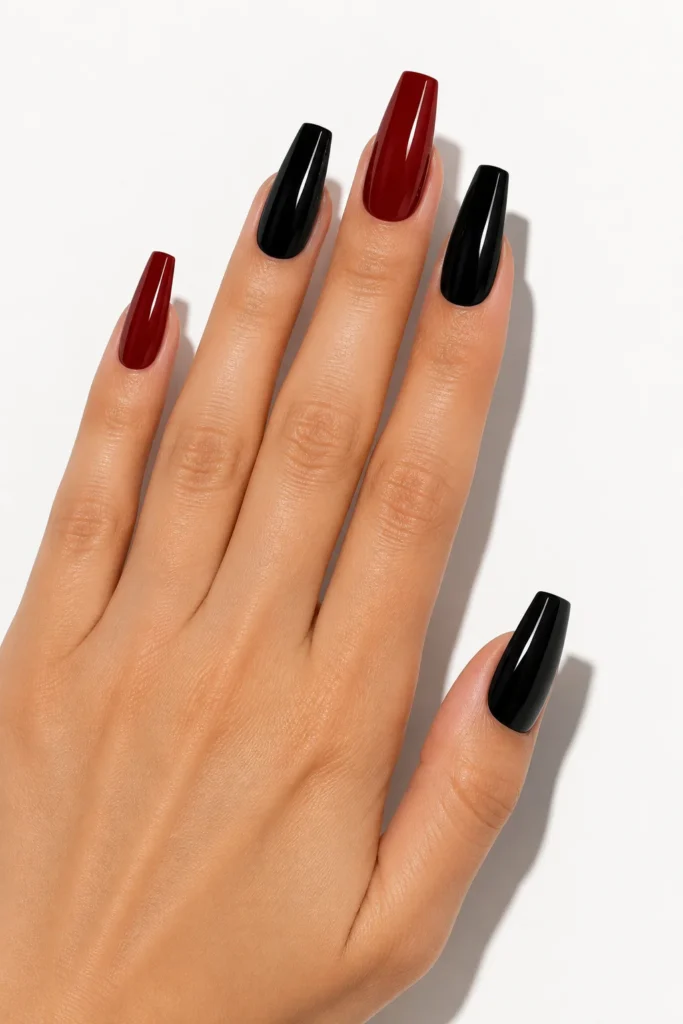 Two-tone dark red and black coffin nails with bold contrasting colors