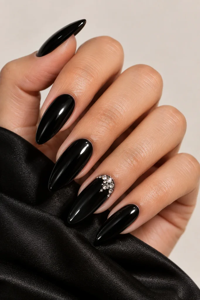 Black almond nails with elegant crystal accents