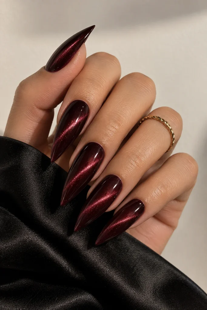 Deep mahogany cat eye nails with dramatic red shimmer