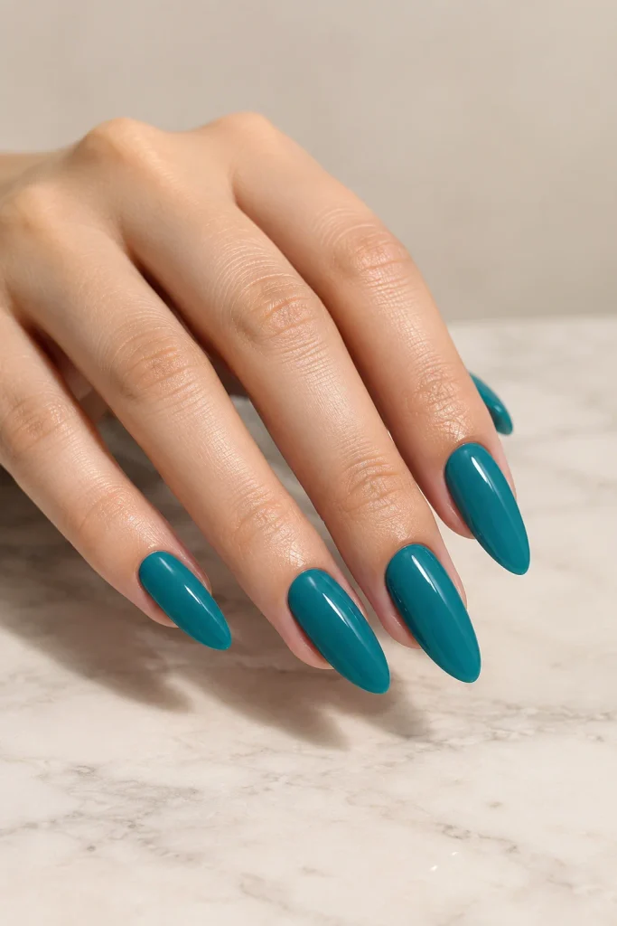 Glossy solid teal nails on medium almond shape