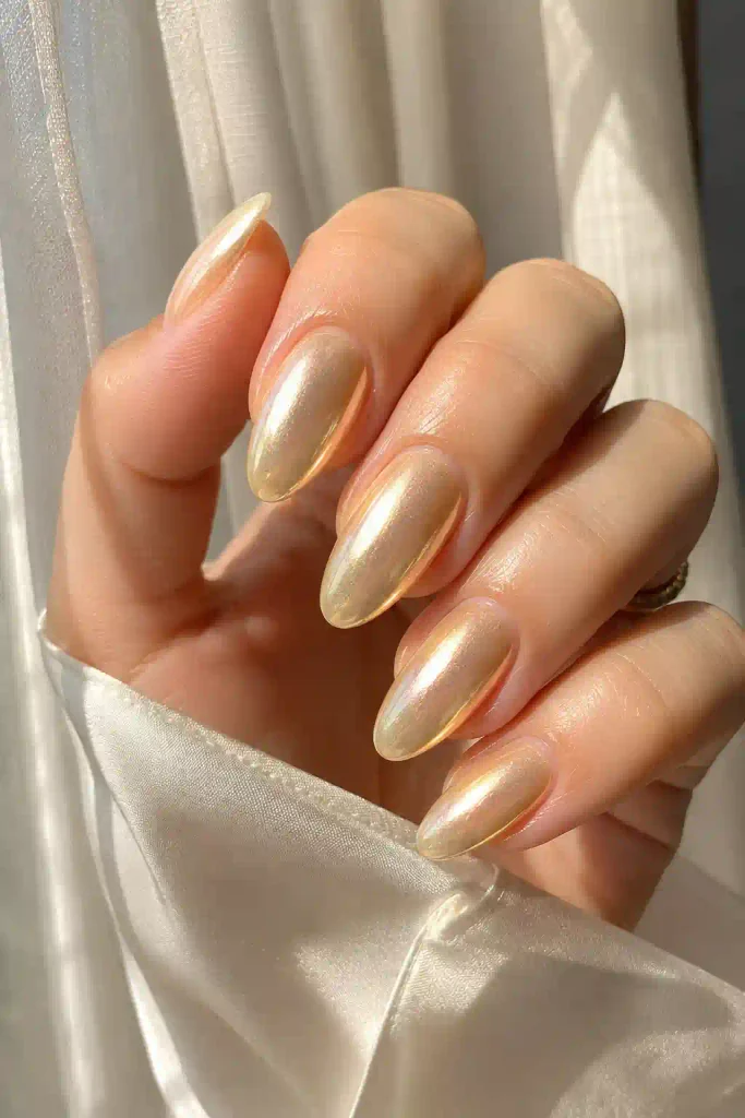 Long almond nails with a glowing golden glazed finish