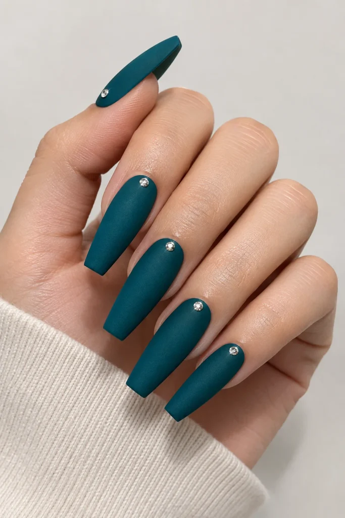 Matte teal nails with single crystal accent