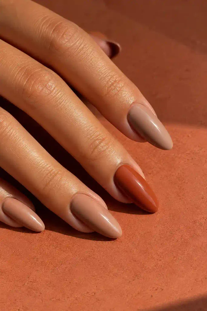 Long almond nails featuring nude and terracotta two-tone colors