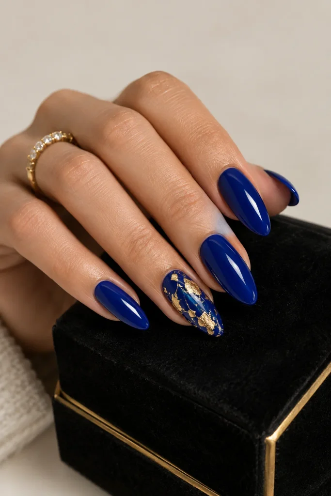 Royal blue nails featuring elegant gold accent details