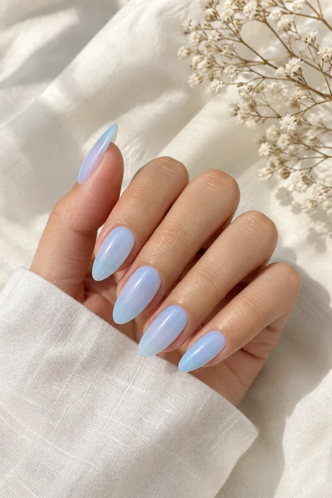 Sheer baby blue almond nails with milky glow