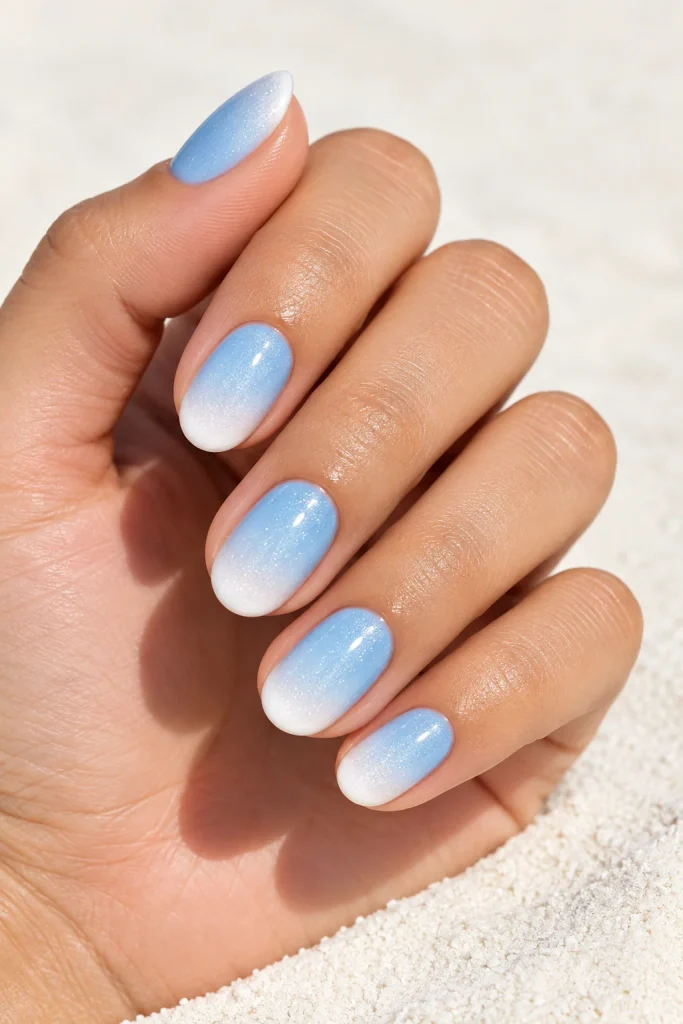 Sky blue fading into white ombre manicure