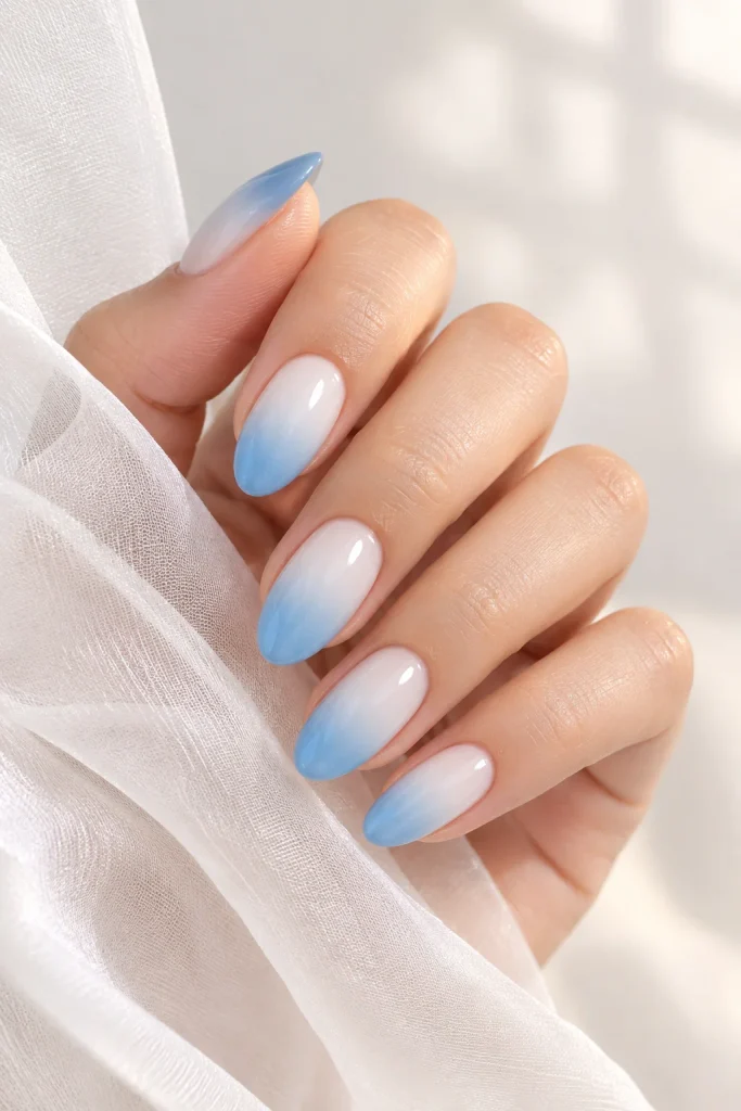 Soft blue ombre nails fading from white base