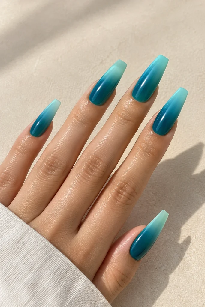 Teal ombre nails blending deep and light shades