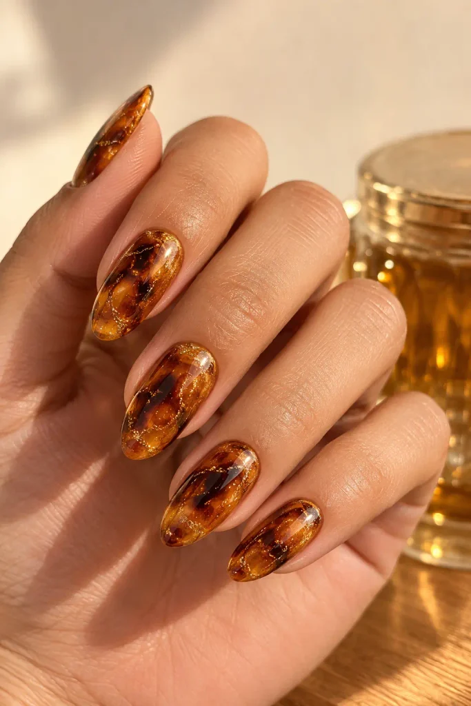 Amber tortoiseshell nails covered with a fine glitter veil