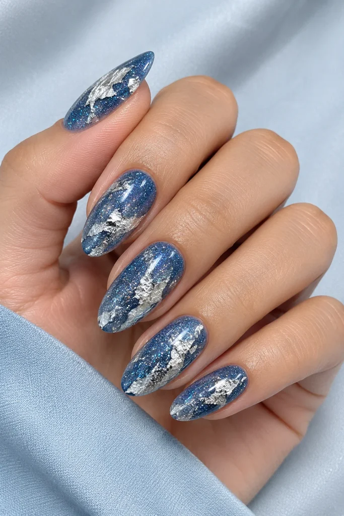Blue glitter nails with silver foil patchwork accents