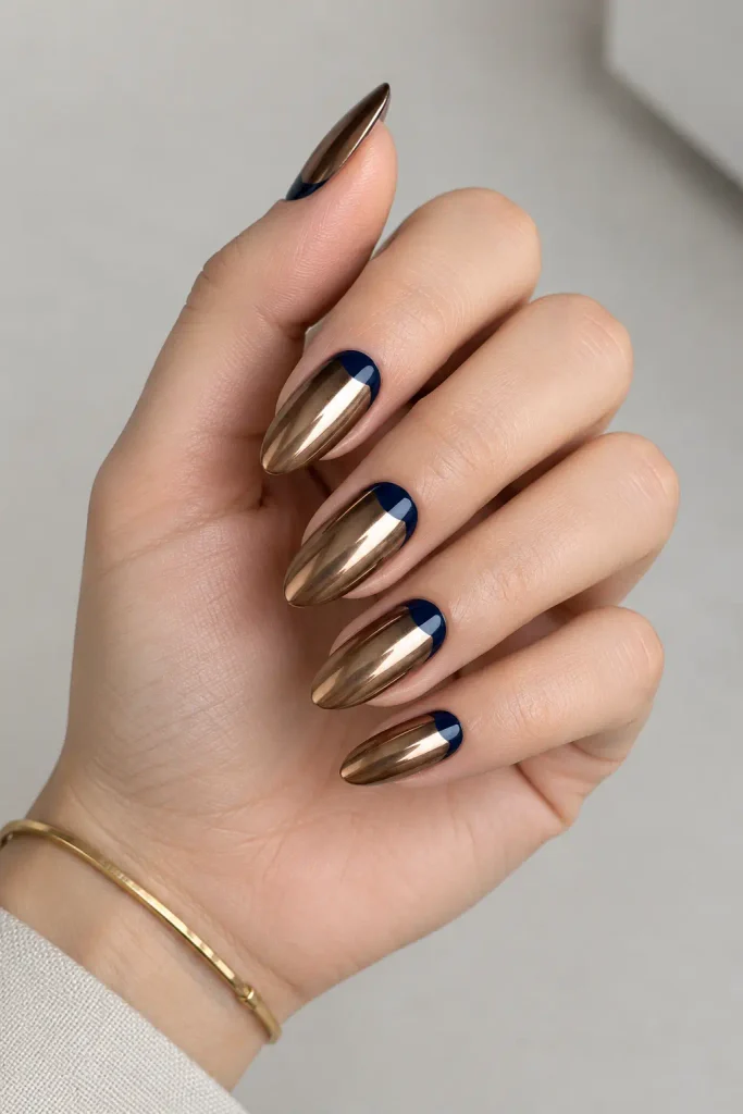 Bronze chrome nails featuring navy blue reverse half moons