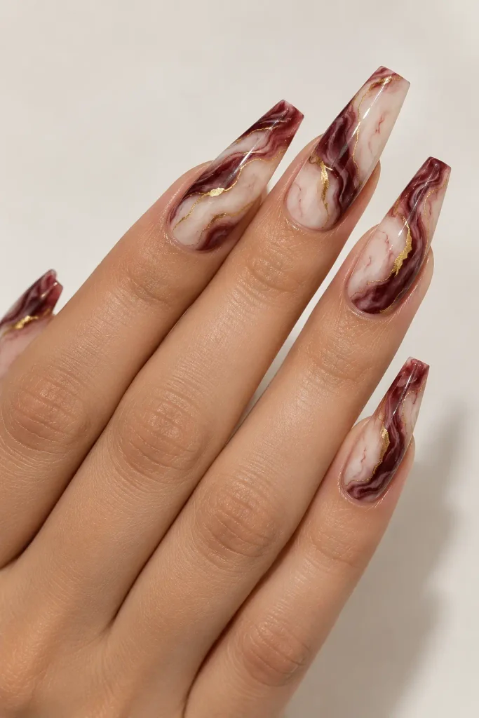 Burgundy marble nails with creamy white and gold veins