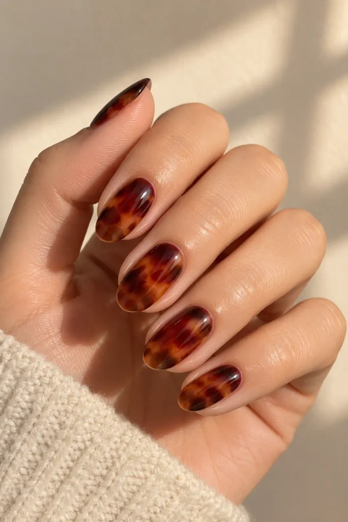 Burgundy tortoiseshell nails featuring caramel and espresso patterns