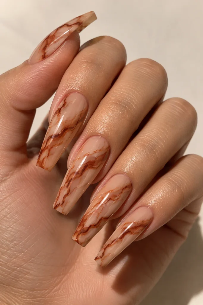 Burnt sienna marble veins over warm nude coffin nails