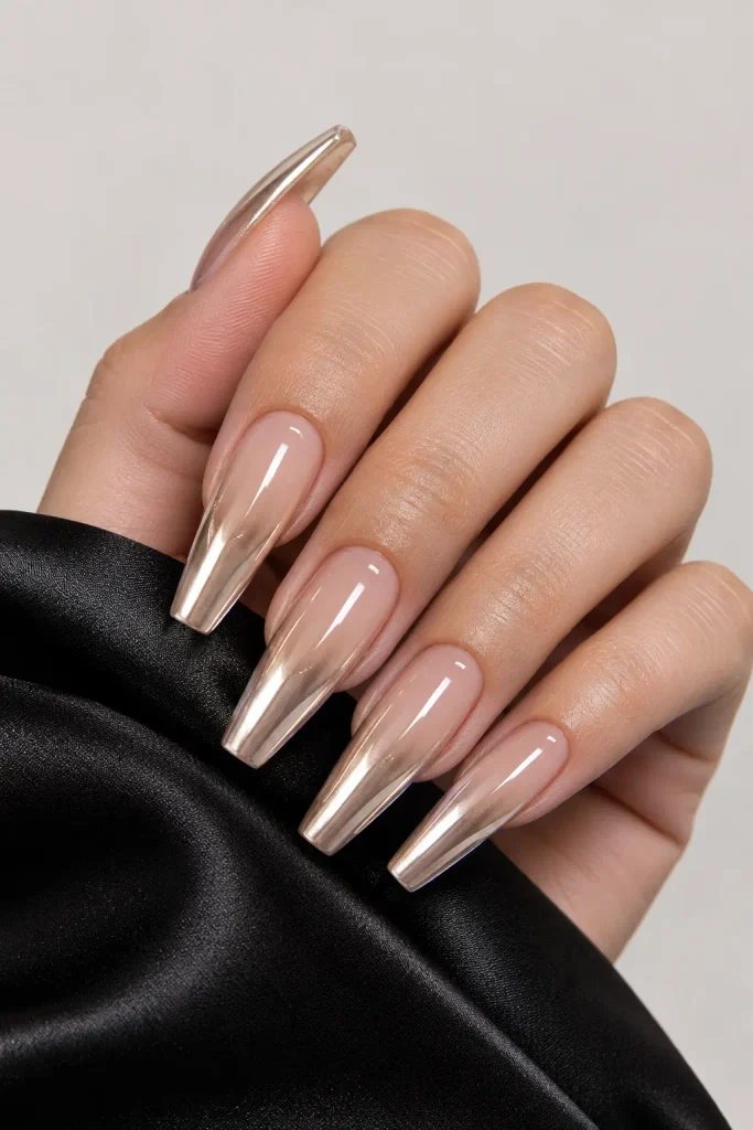 Champagne chrome almond nails over a sheer nude base