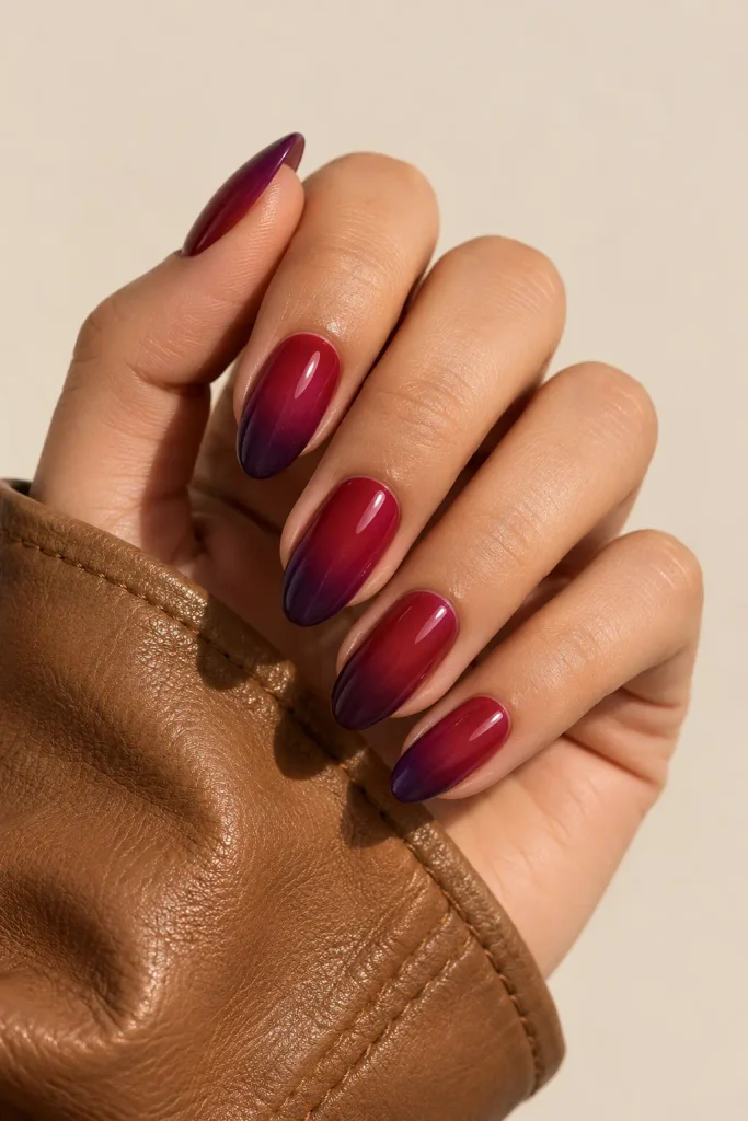 Almond nails blending deep cherry into dark plum shades