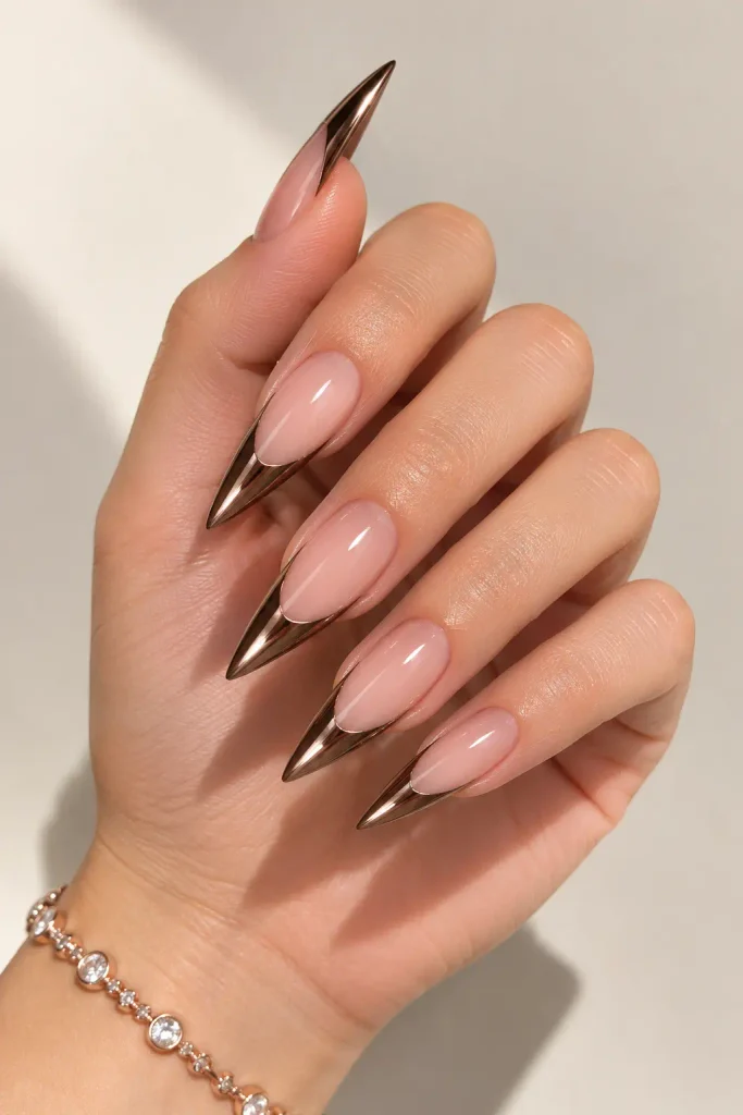 Chocolate chrome stiletto French tips over a sheer nude base.