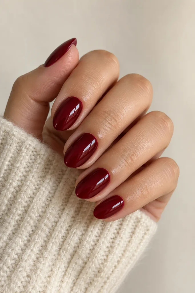 Glossy deep cherry red polish on short almond nails