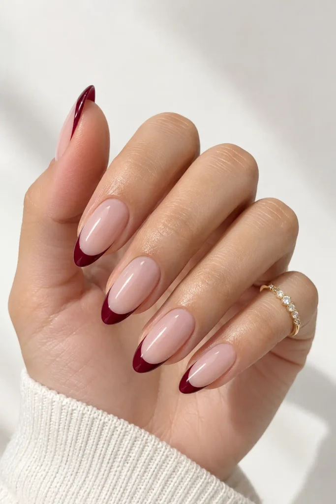 Sheer nude nails with thin deep cherry French tips