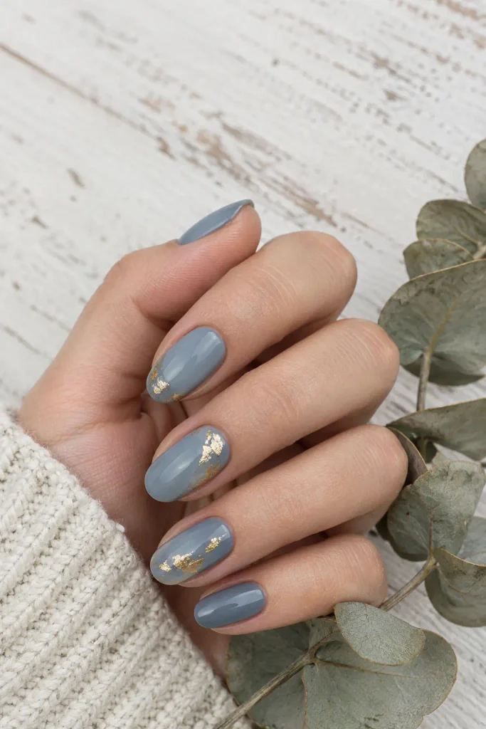 Dusty blue oval wedding nails decorated with delicate gold foil accents.