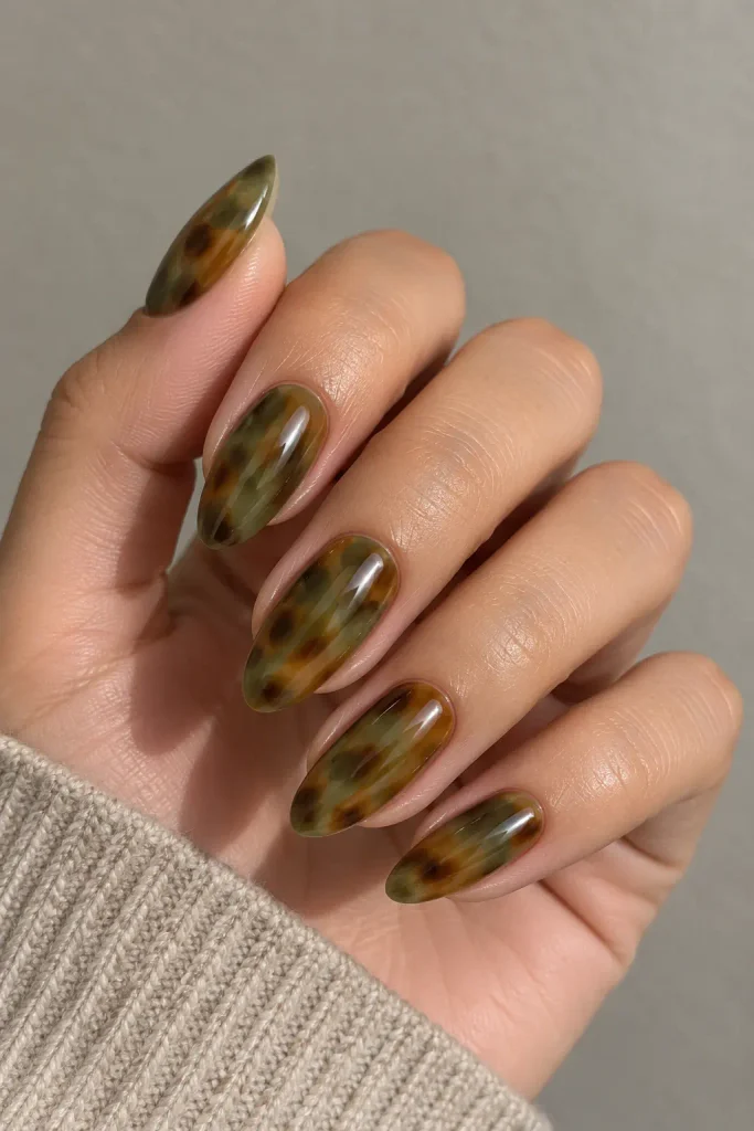 Eucalyptus green tortoiseshell nails with swirling brown patterns