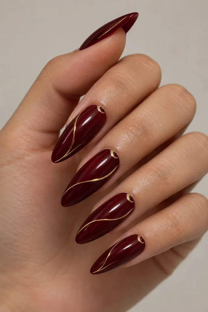 Deep cherry nails featuring delicate fine gold line art