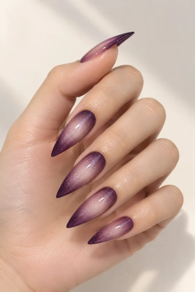 Plum aura stiletto nails with glowing mauve gradient centers.