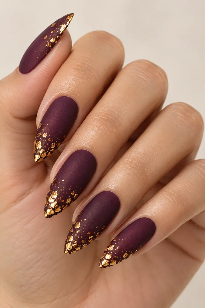 Plum matte nails with delicate gold foil flakes