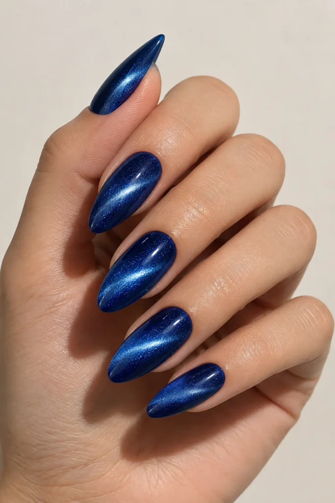 Royal blue almond nails featuring a magnetic velvet cat-eye finish.