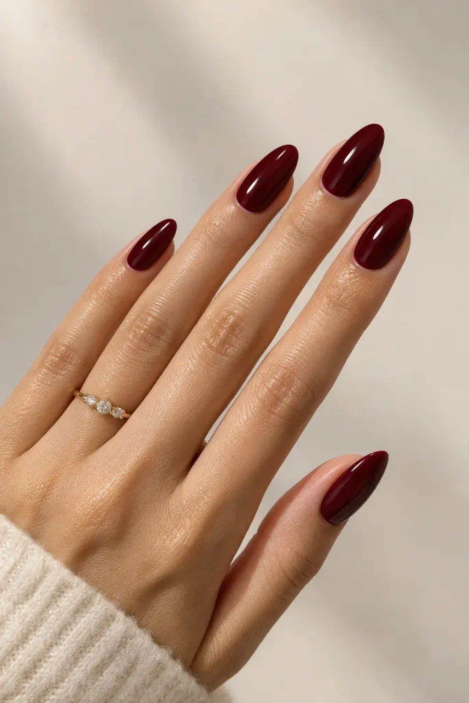 Deep wine burgundy almond nails with a smooth glass-like glossy finish.